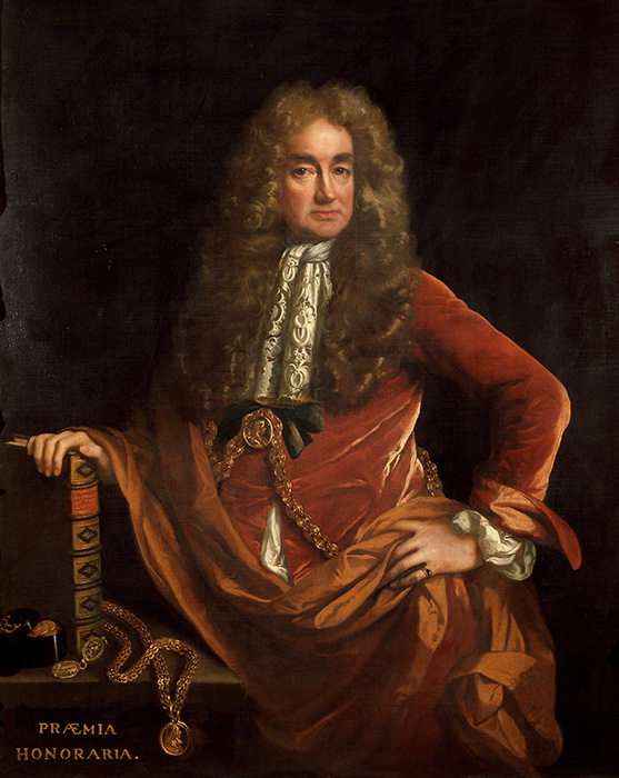 Elias Ashmole portrait, he iis wearing a dark red velvet coat and has one hand on his hip and the other on the arm of a chair