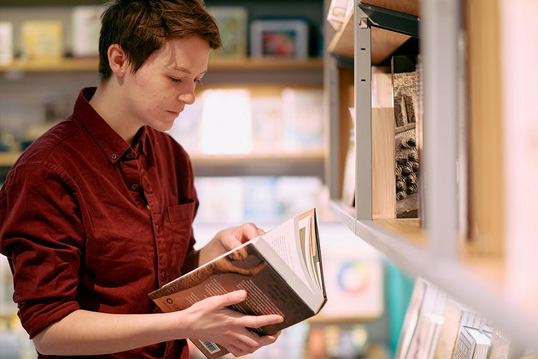 Member in Exhibition shop browsing a book