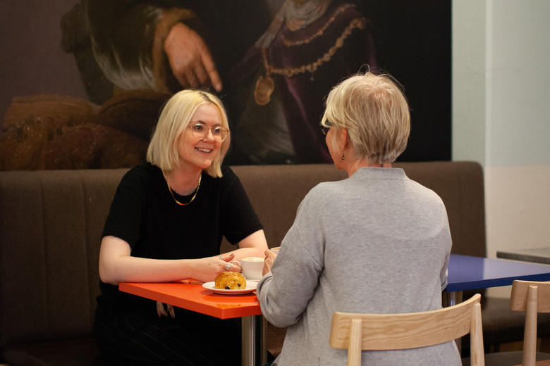 Two women have coffee at the Rembrandt cafe.