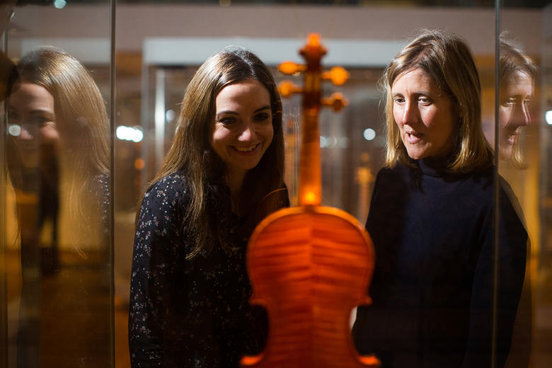 Two women look at a Stradivarius violin in the music gallery