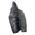 A small black fragment of a rhyton (a conical container) with figures, bricks and plants embossed on the surface