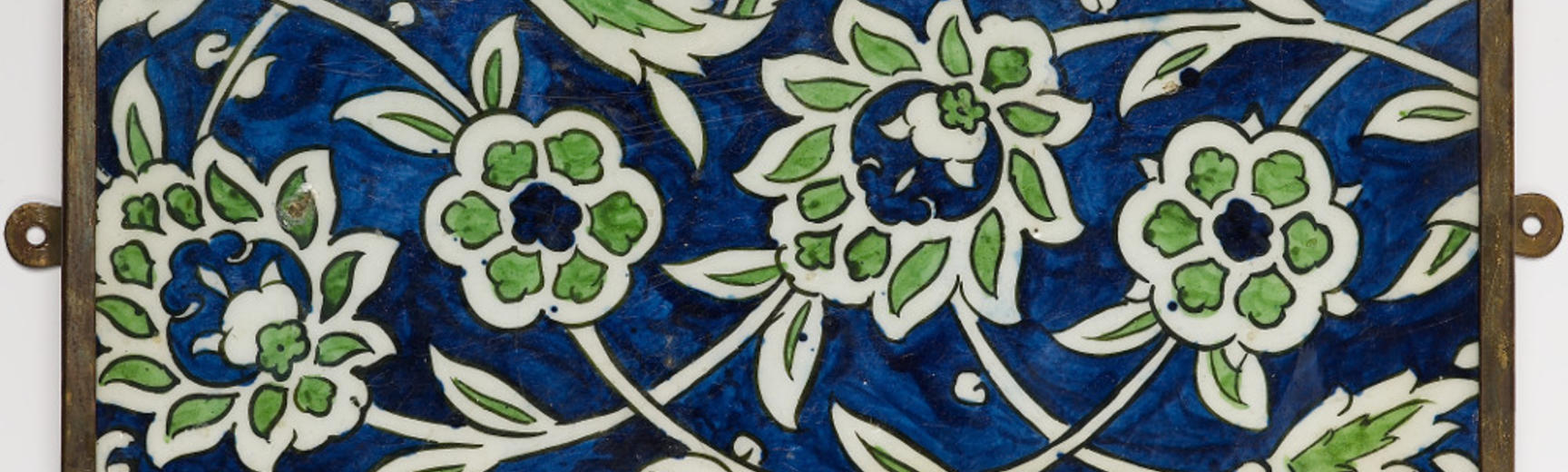 A blue tile patterned with a green flowers.