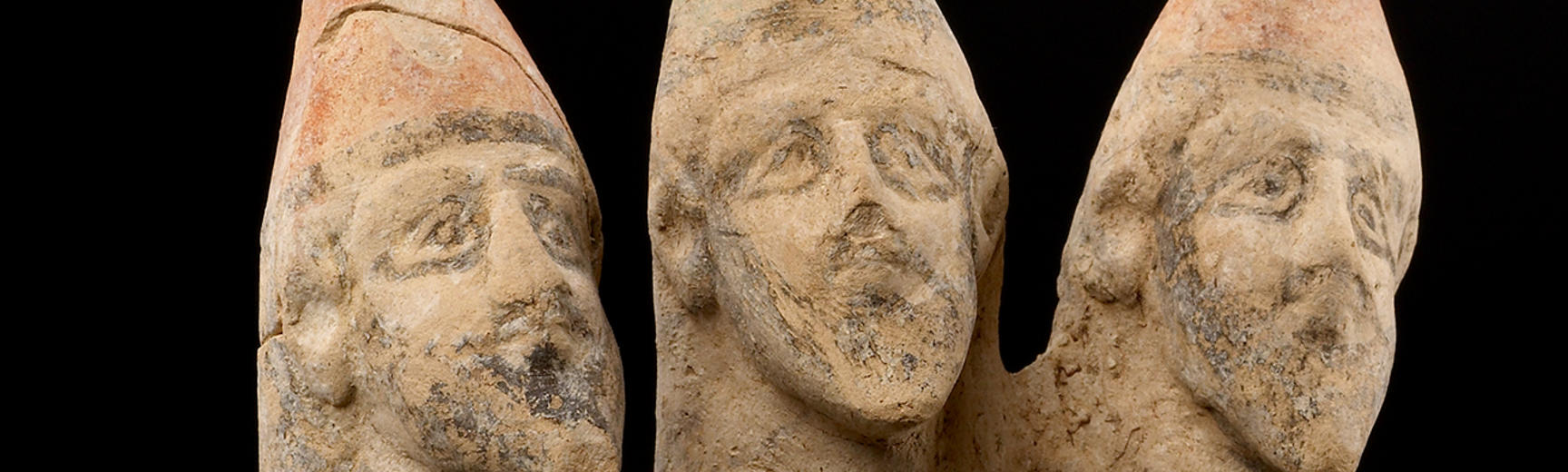 A stone sculpture of three male heads