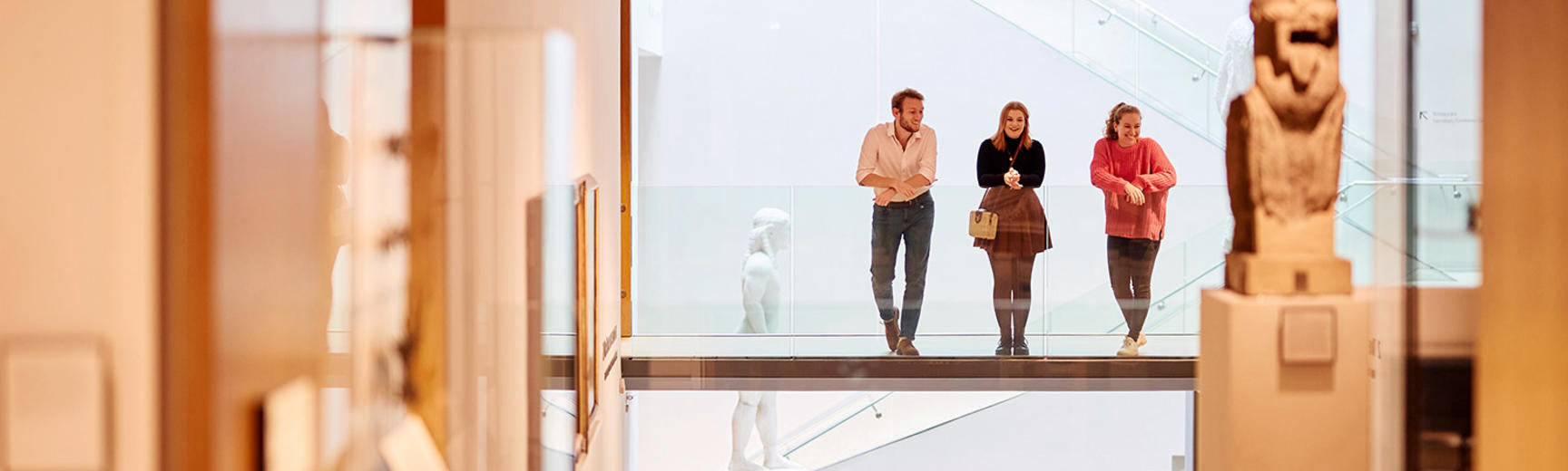 Visitors in the atrium looking down at the galleries from the central walkway