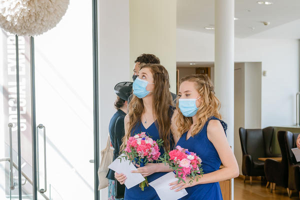 Portrait photo of two bridesmaids dressed in blue wearing face masks