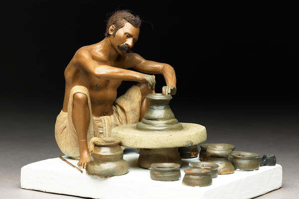 Model depicting a potter turning a pot on a wheel