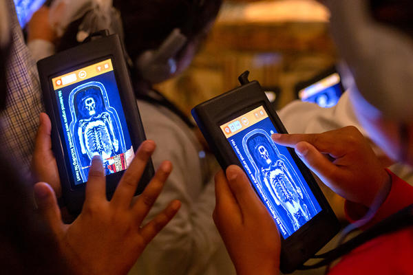 Family playing with the drawing interactive on the Ashmolean Adventure in the Egypt galleries