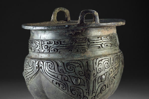A pot like vessel decorated in taotie masks