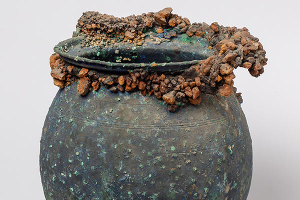 Cooking pot with volcanic debris encrusted around the rim