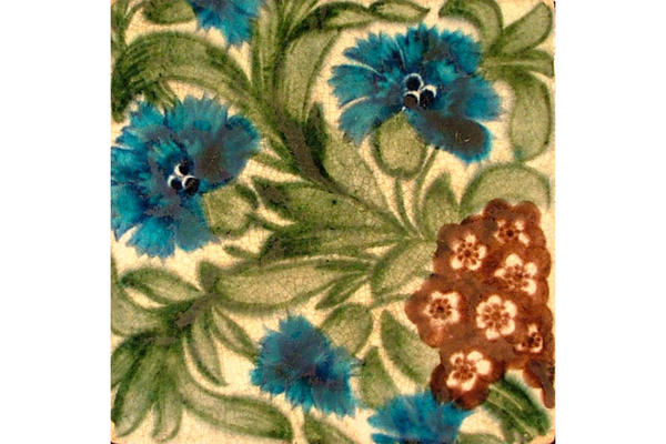 Colourful tile in a William Morris design with 5 blue cornflowers, red primroses and green leaves