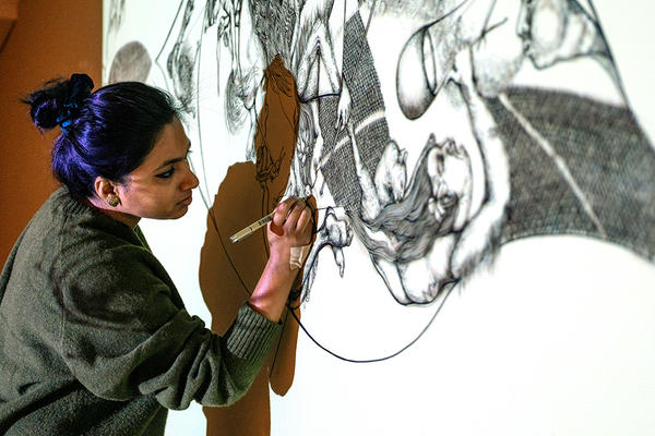 Artist Surovi at work on her mural in her exhibition in Gallery 8