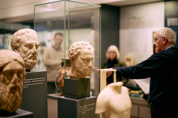 Gallery tour group with tour leader surrounded by heads and torsos