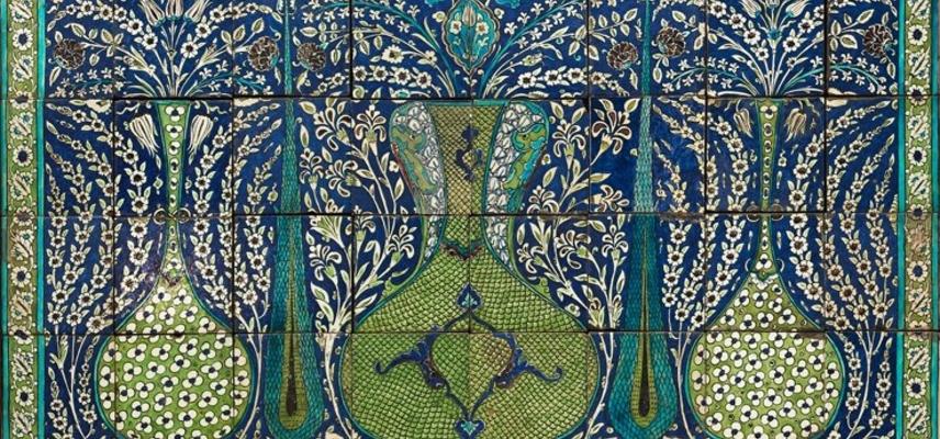 Mosaic of small blue, green and yellow tiles forming a picture of vases and trees amid flowers