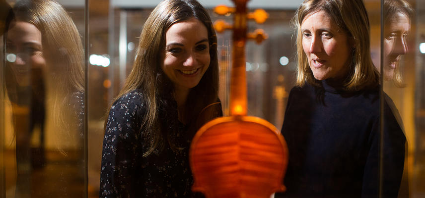 Two women look at a Stradivarius violin in the music gallery