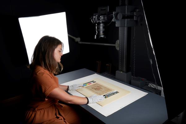 Staff member in the process of photographing a work on paper