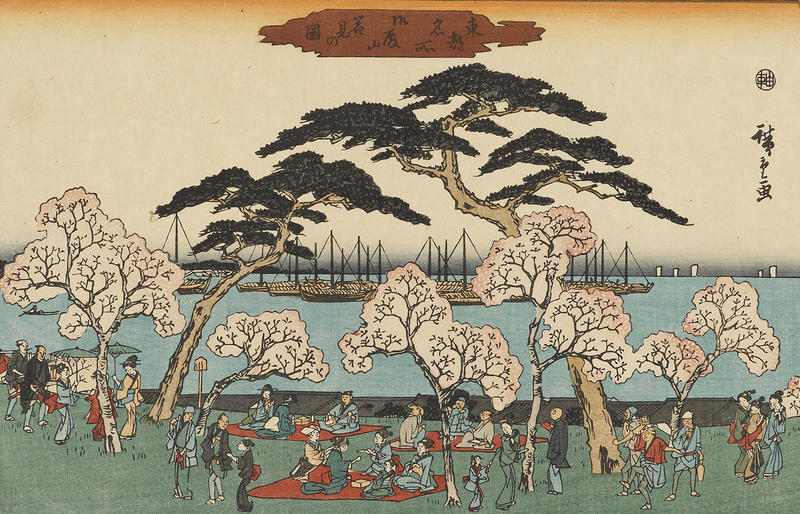 A woodblock print of a landscape featuring a group celebrating beneath cherry blossoms by the sea
