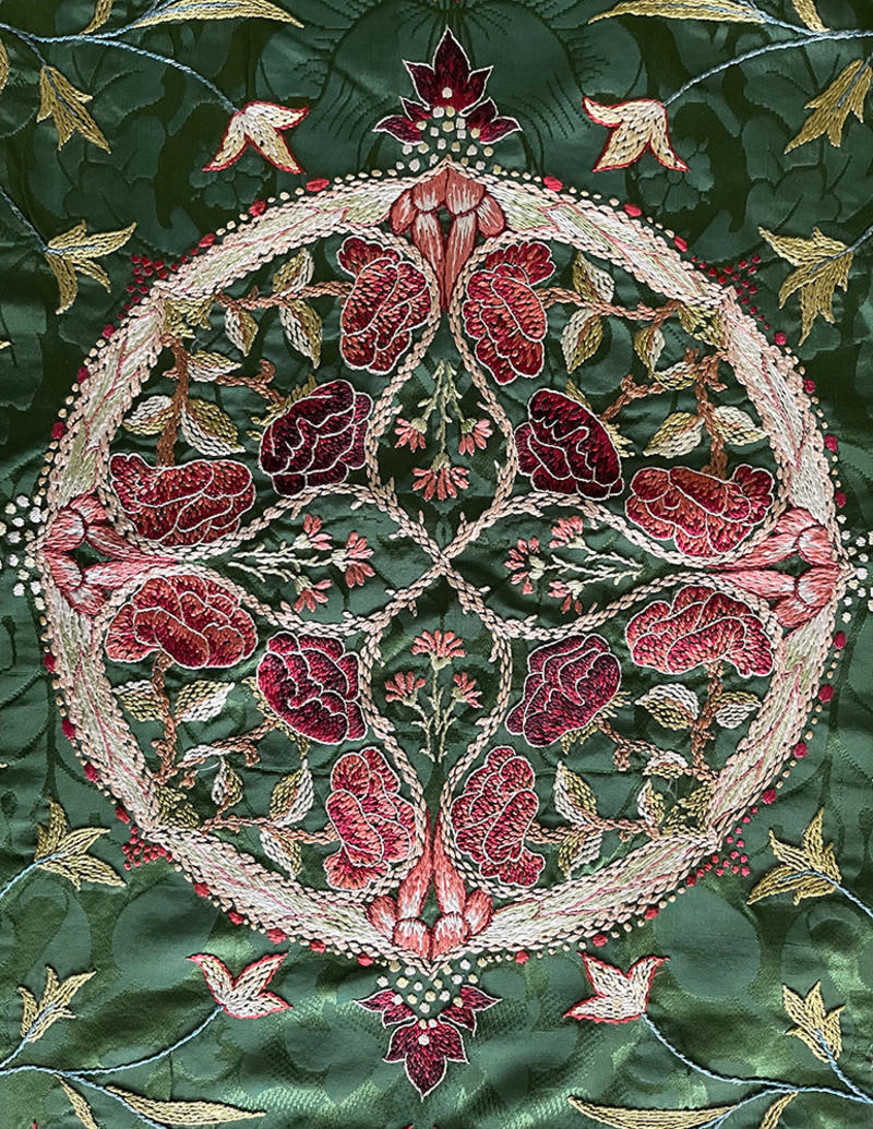 Richly embroidered table cover in silks and reds and greens, designed by May Morris