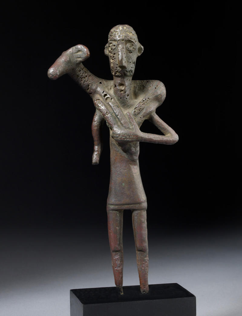 Bronze age figurine of a worshipper carrying a ram