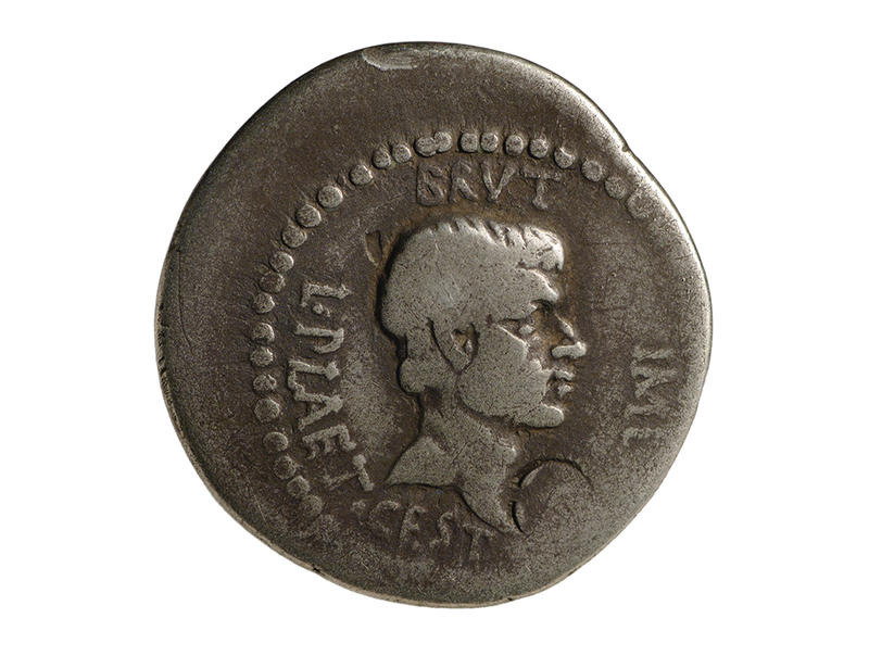 Roman silver coin with dotted edge detail, inscriptions and bust of Brutus facing to right