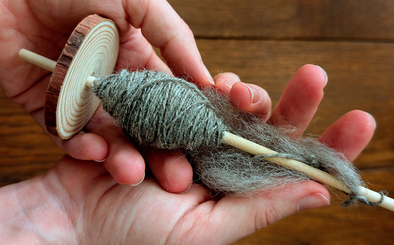 Close up of a drop spindle with yarn used in drop spinning