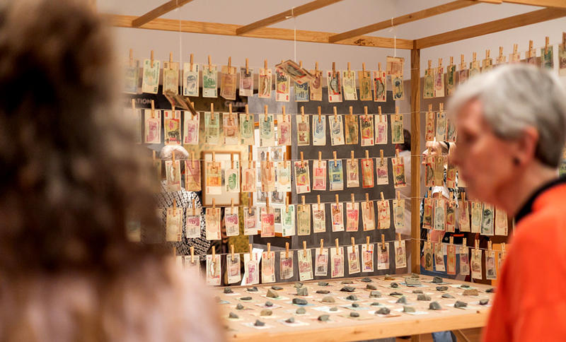 Visitors looking at the Bank or Economy – Inflation banknotes installation by Meschac Gaba in our Money Talks exhibition