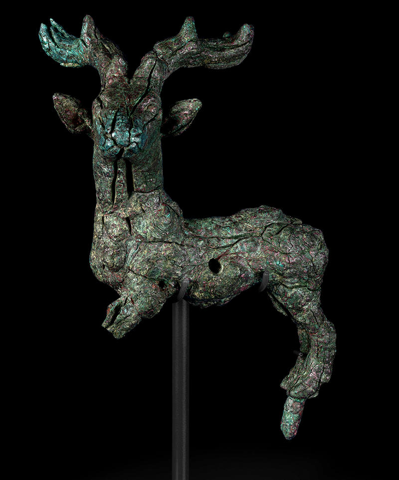 Green stag figurine on a stand