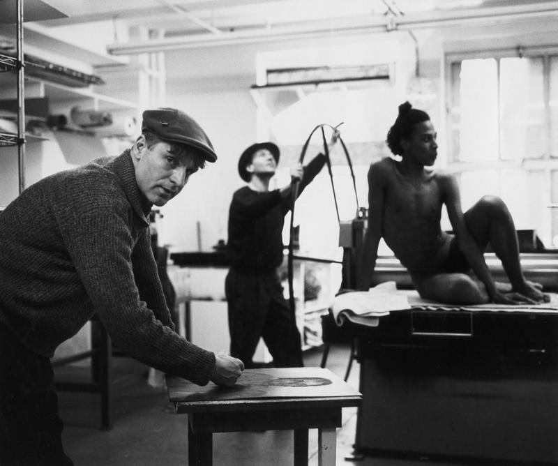 Black and white photograph of the artist Rainer Fetting, and two others, in a studio in 1989