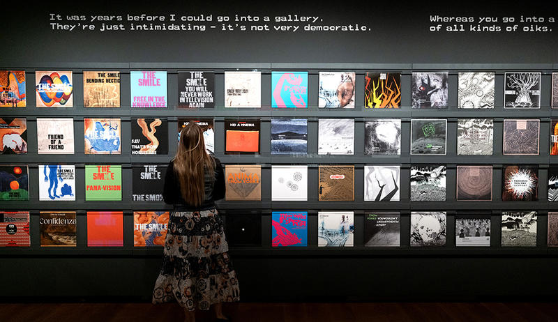 This Is What You Get exhibition wall of albums display Visitor in the This Is What You Get exhibition looking at the large wall display of Radiohead and more albums