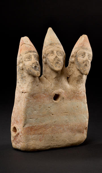 A ceramic sculpture of three male heads