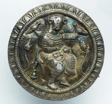 Metal sculpture of Hariti seated on a bird throne with a sick child in her lap