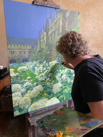 Francis Hamel painting an Oxford college garden scene with his easel looking out at blooming white hydrangeas