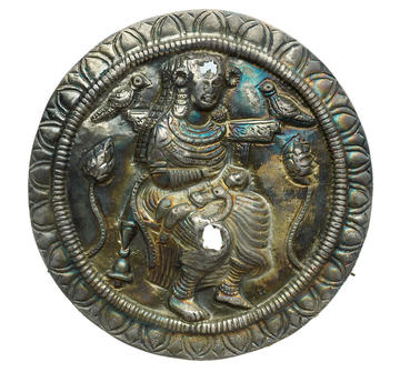 Metal sculpture of Hariti seated on a bird throne with a sick child in her lap