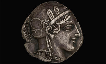 Silver coin decorated with profile of Greek warrior
