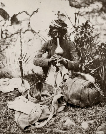 Black and white photograph of a snake charmer taken by Colonel Impey in colonial India