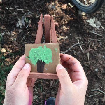 A child holds up their little canvas at the Painting in the Park family event in Oxford in March