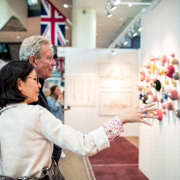 couple looking at displayed art in an art fair