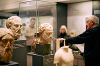 Gallery tour group with tour leader surrounded by heads and torsos